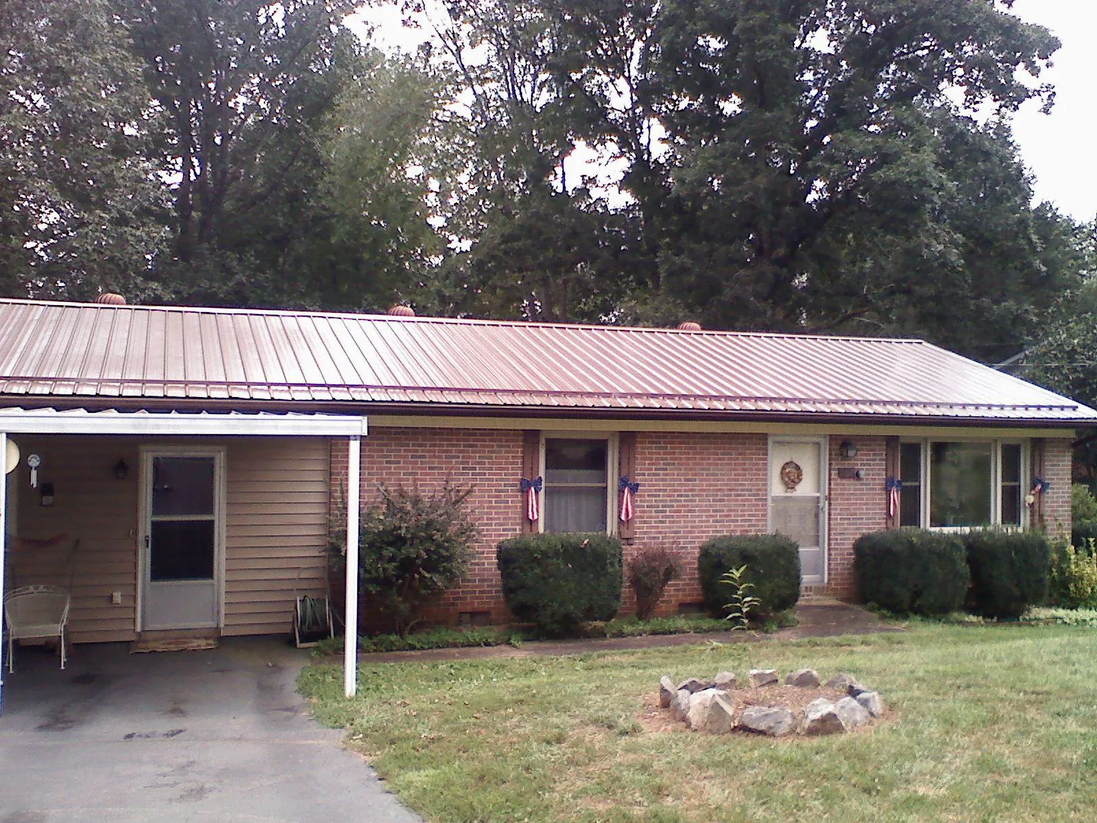 Bronze metal roof and carport on a brick ranch home — Roof Repair work by our crew in North Charleston