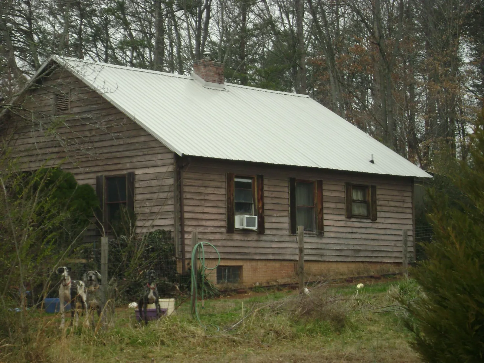 White metal roof on an old wood sided farmhouse, from a Metal Roof Installation job in North Charleston